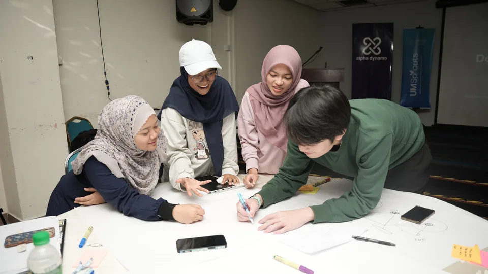 Four Universiti Malaya participants working together on their design thinking exercise