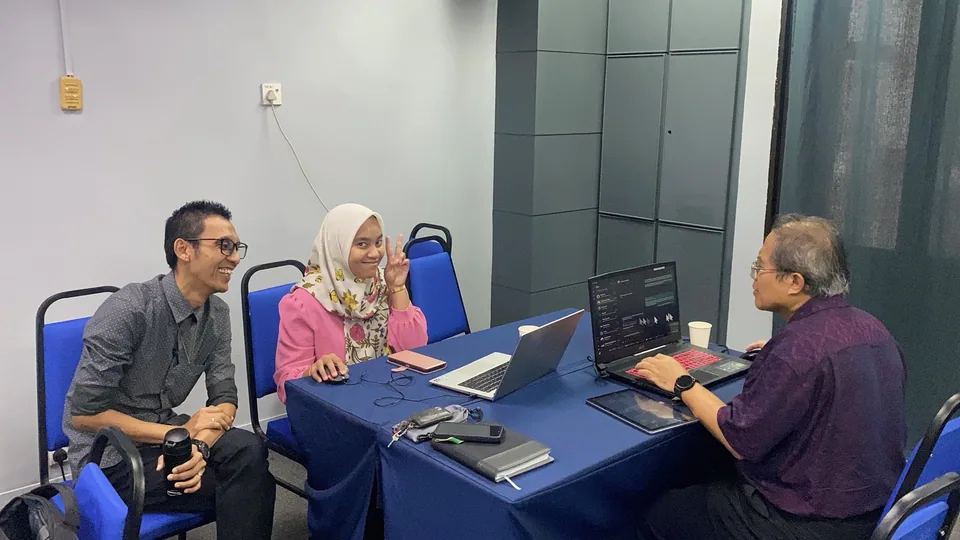 A facilitator helping researchers work through an idea on their laptops